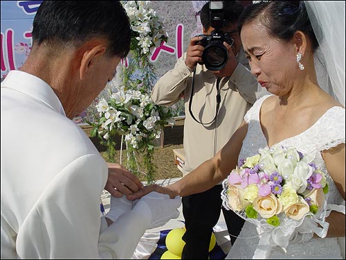 종철씨가 영례씨에게 결혼반지를 끼워주며 사랑을 맹세하고 있다 